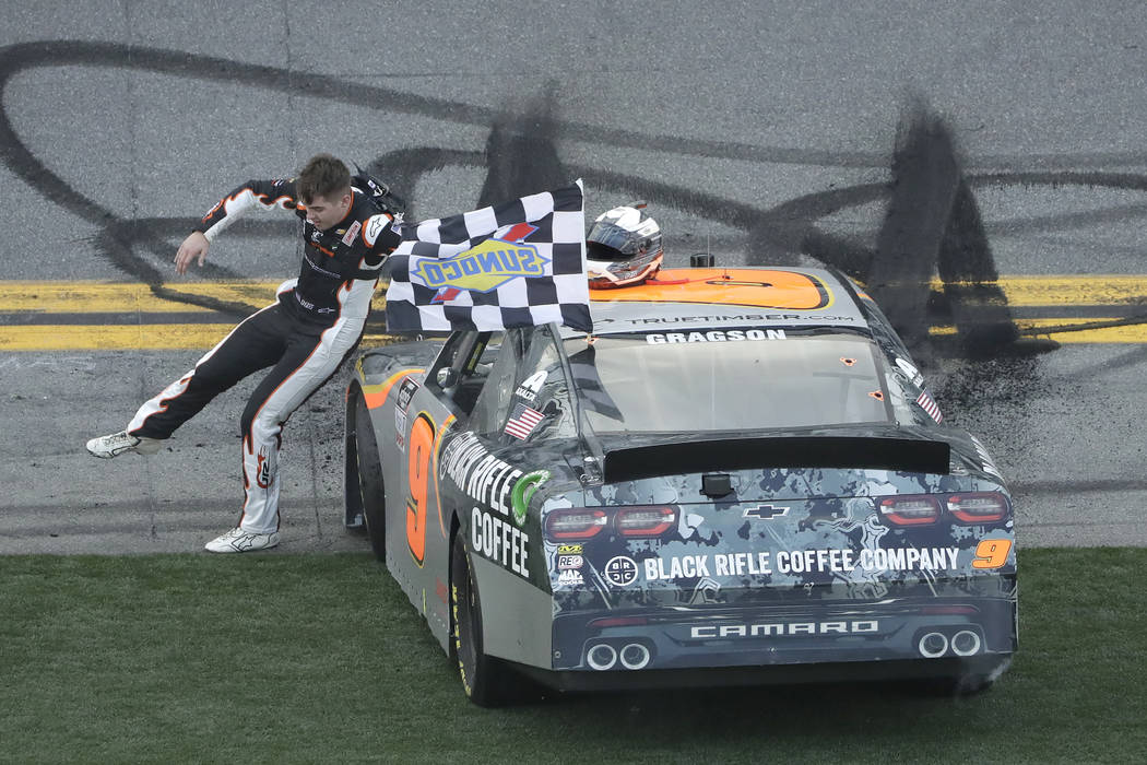 Noah Gragson slides across the hood of his car as he celebrates winning the NASCAR Xfinity seri ...
