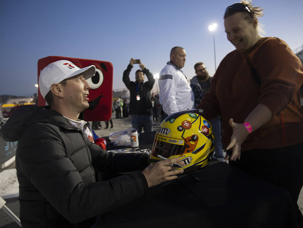 Sondra Peterson, right, gets her helmet signed by NASCAR star Kyle Busch before the start of th ...