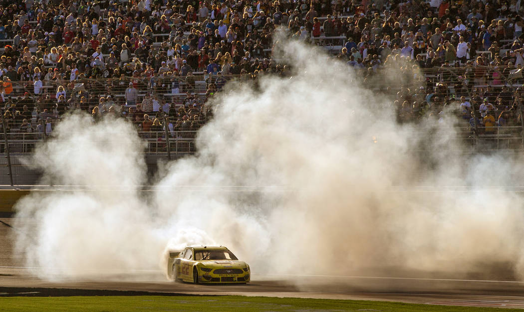 Joey Logano (22) celebrates with a burn out at the finish line following his win in the Pennzoi ...