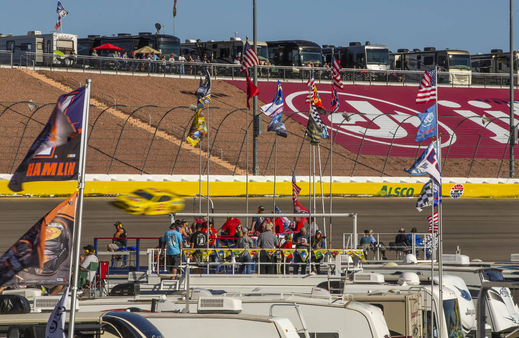 Fans watch Joey Logano (22) race by from atop their RV's in the infield during the Pennzoil 400 ...