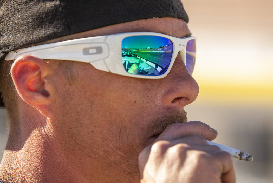 Fan Lucky Henderson has the race reflected in his sunglasses during the Pennzoil 400 presented ...