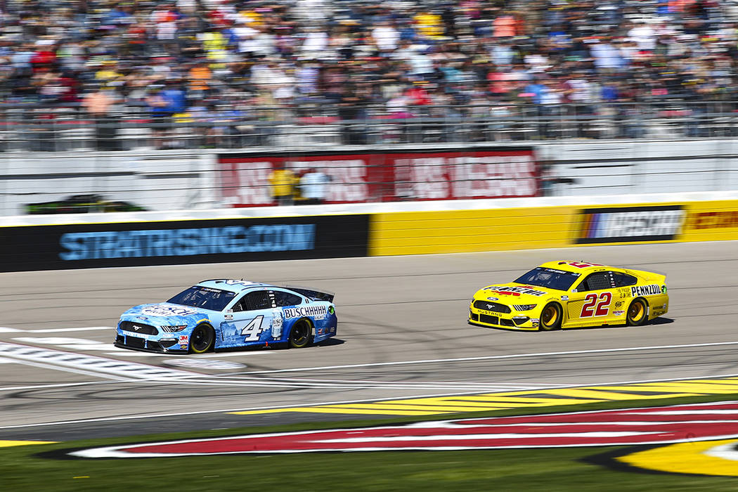 Kevin Harvick (4) and Joey Logano (22) drive during a NASCAR Cup Series auto race at the Las Ve ...