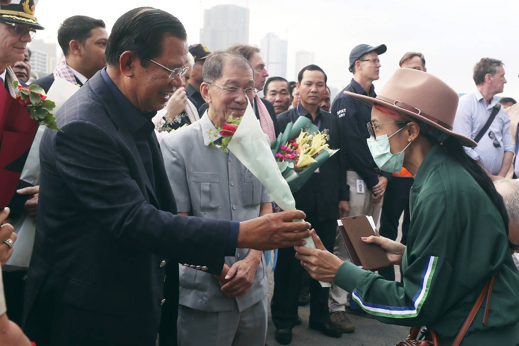 In a Feb. 14, 2020, file photo, Cambodia's Prime Minister Hun Sen, left, gives a bouquet of flo ...
