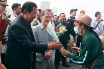In a Feb. 14, 2020, file photo, Cambodia's Prime Minister Hun Sen, left, gives a bouquet of flo ...
