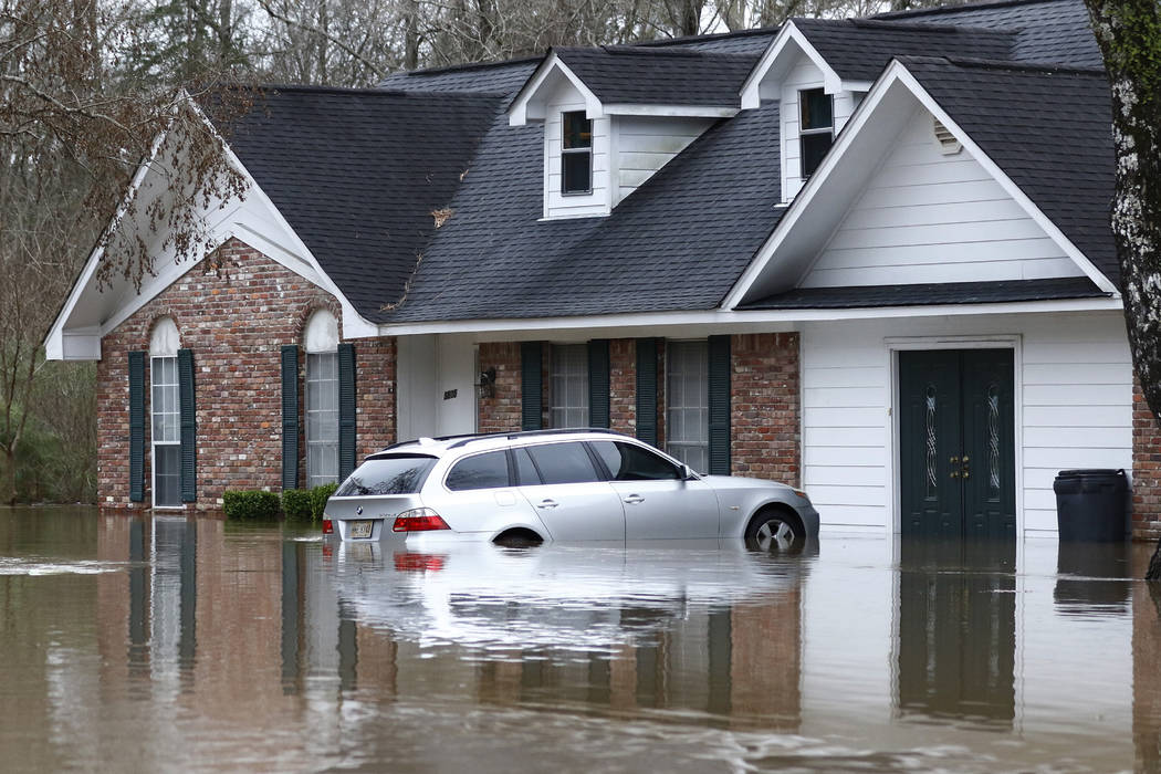 Water from the Pearl River floods this northeast Jackson, Miss., home and car, Sunday, Feb. 16, ...