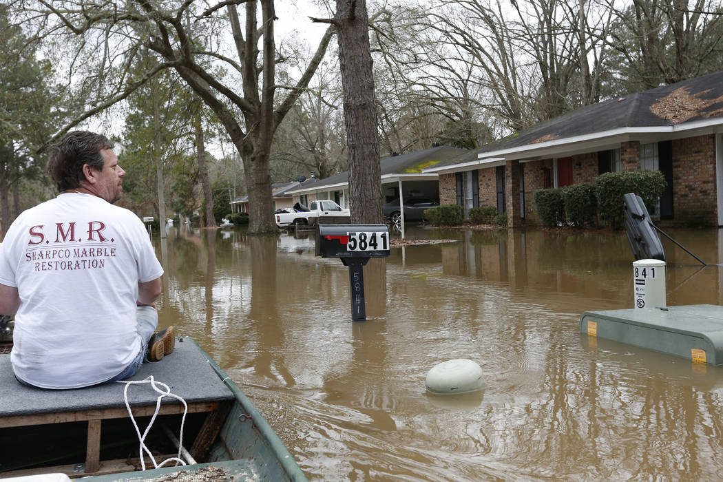 Chris Sharp studies the water damage from the Pearl River that floods his neighborhood in Jacks ...