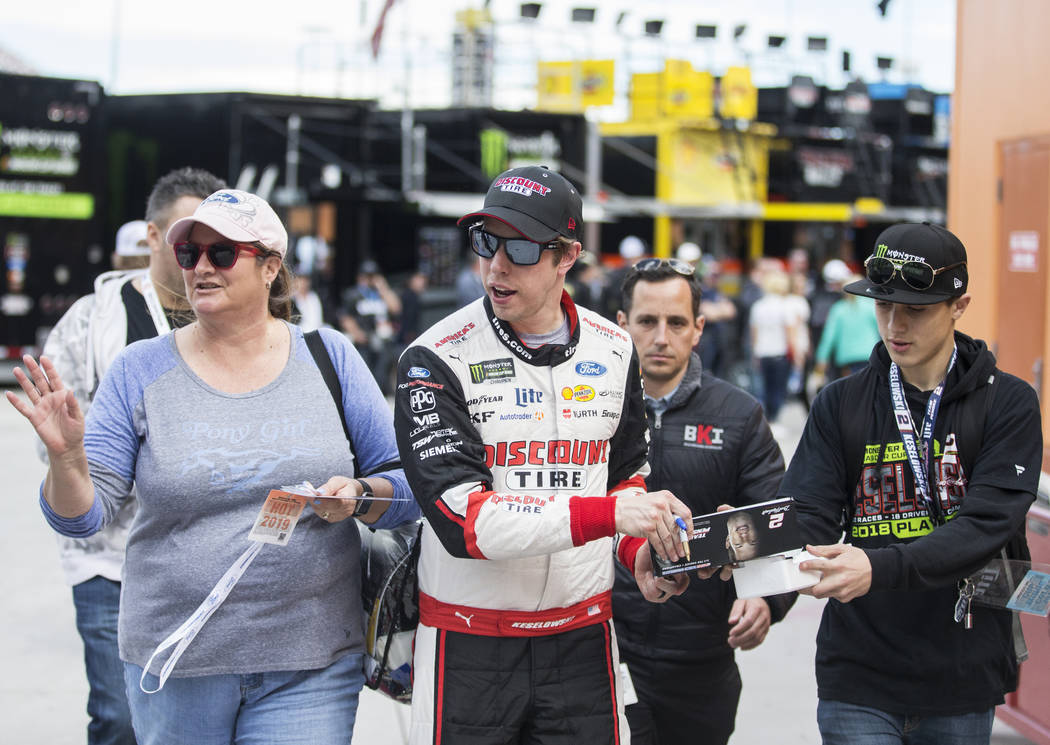 Brad Keselowski, middle, walks in pit row after completing his practice run on Saturday, March ...