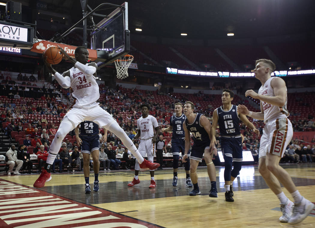 UNLV's forward Mbacke Diong (34) grabs the ball on defense as Utah State players look on during ...