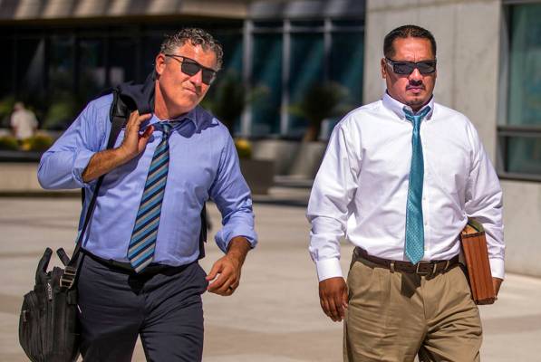 Counselor Mark Fleming, left, walks out with defendant Albert Lopez outside the Lloyd D. George ...