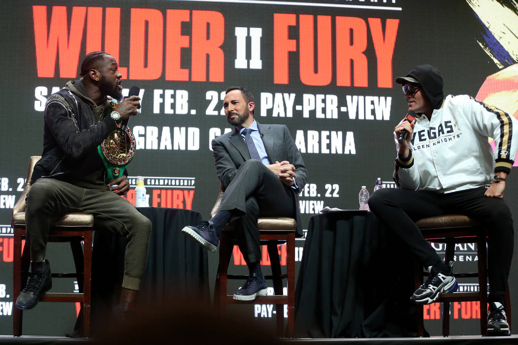 Deontay Wilder, left, and Tyson Fury, participate in a press conference as moderator sportscast ...