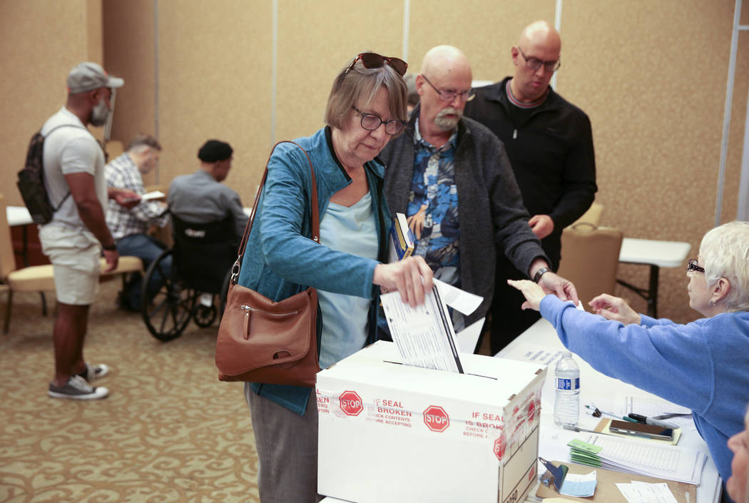 Leslie Doughman, 64, of Henderson, drops her ballot in the box during early voting in the Nevad ...