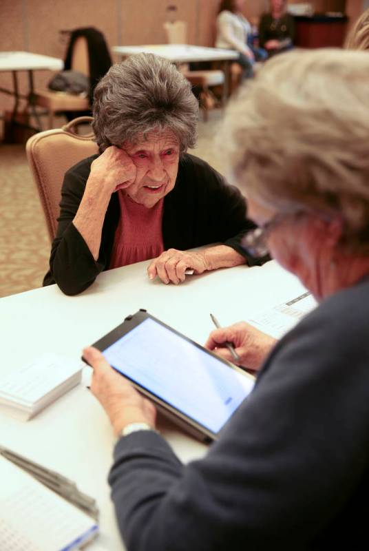Joann Dunn, 99, checks in with volunteer Ramonda Haycocks, both of Henderson, during early voti ...