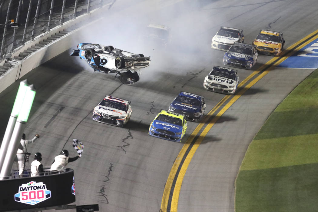 Denny Hamlin, front left, passes Ryan Blaney, front right on the way to the finish line to win ...