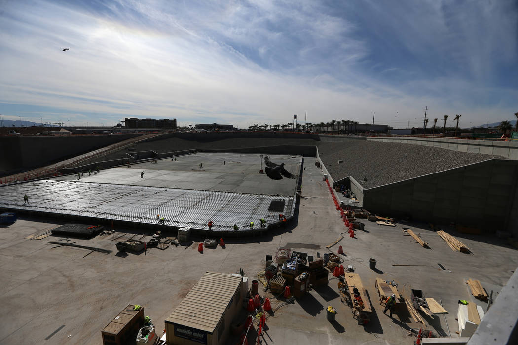 Construction workers prepare a section of the field tray to pour cement at the Raiders Allegian ...