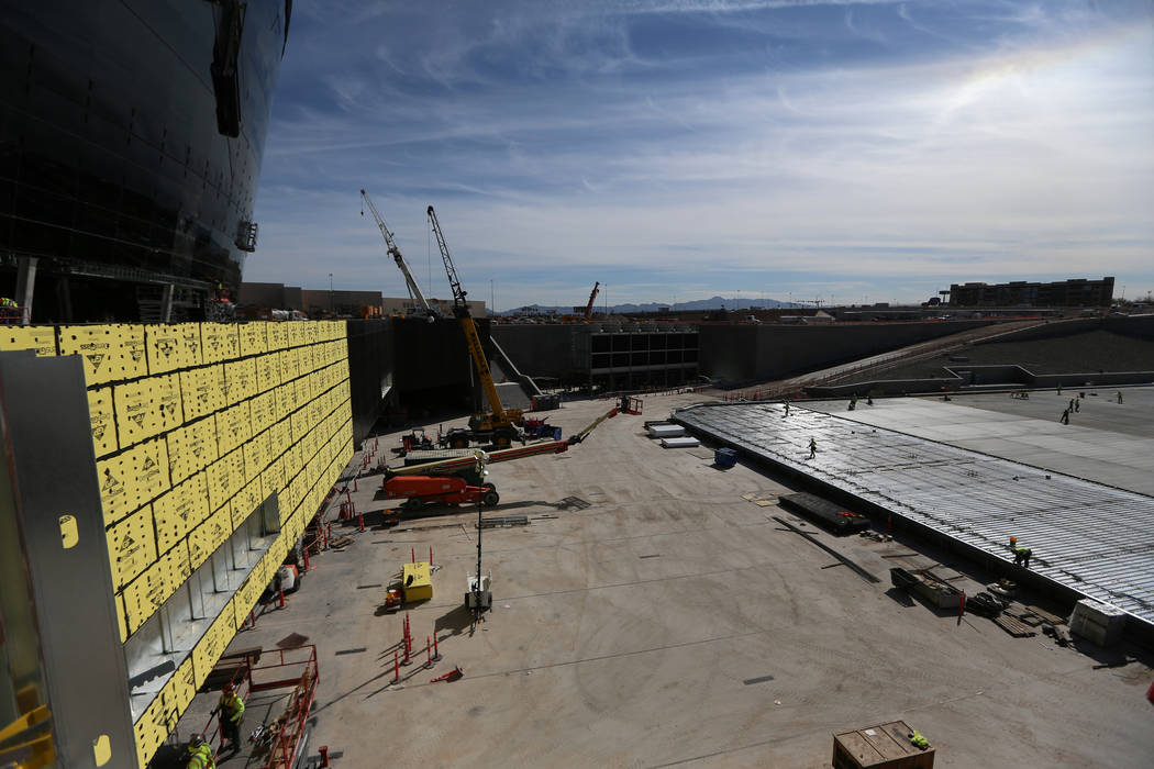 Construction workers prepare a section of the field tray to pour cement at the Raiders Allegian ...