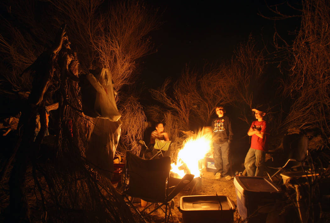Children gather around a campfire while camping in Saline Valley at Death Valley National Park. ...