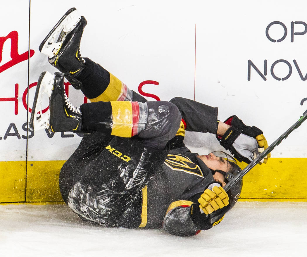 Vegas Golden Knights defenseman Zach Whitecloud (2) hits his head on the boards after being tri ...