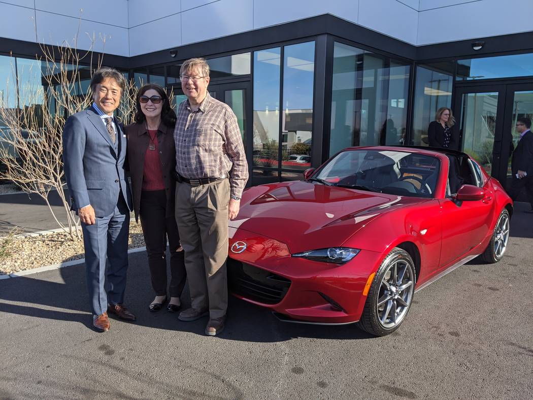 Mazda North American Operations chairman and CEO Masahiro Moro, left, poses with a couple who p ...