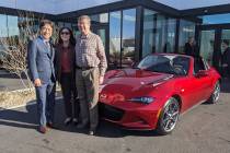 Mazda North American Operations chairman and CEO Masahiro Moro, left, poses with a couple who p ...