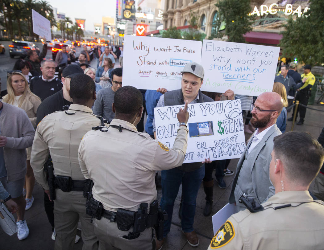 Woodrow Johnston, middle/holding sign, is directed to stop blocking traffic by Metro officers o ...