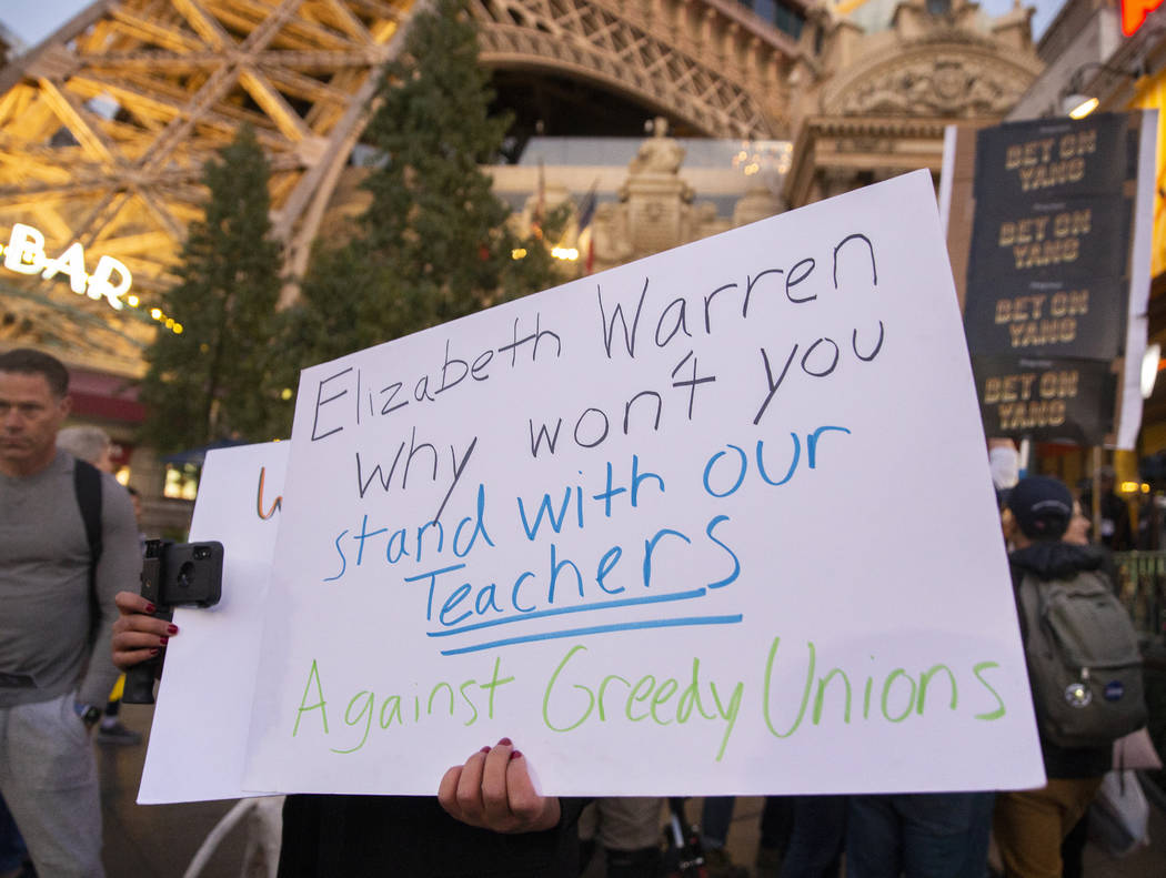 Supporters of local teachers hold signs on the Strip outside Paris before the start of the Neva ...