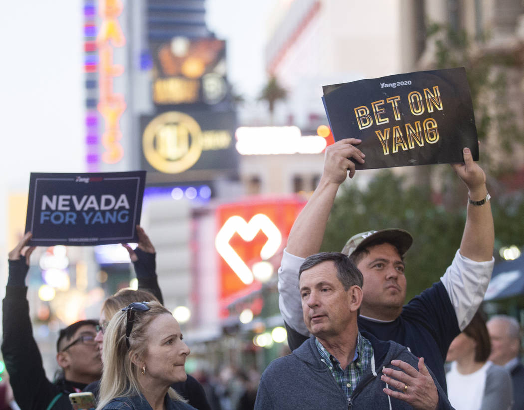 Supporters of former Democratic presidential candidate Andrew Yang hold signs on the Strip outs ...