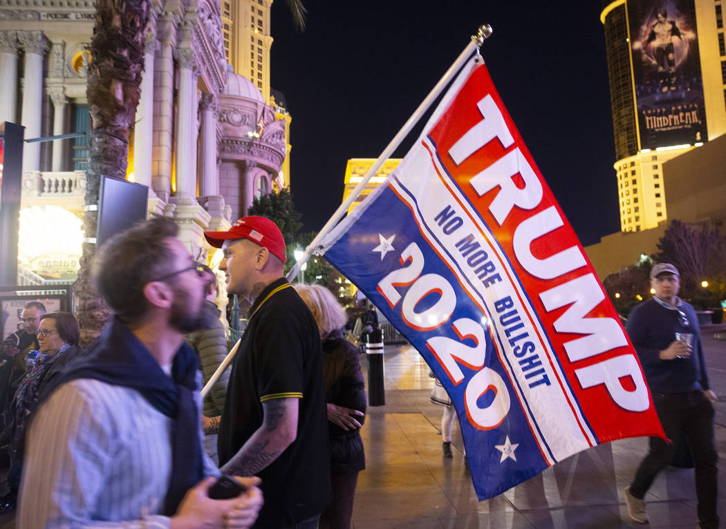 Timothy Lynne, from Henderson, holds a flag supporting President Donald Trump on the Strip outs ...