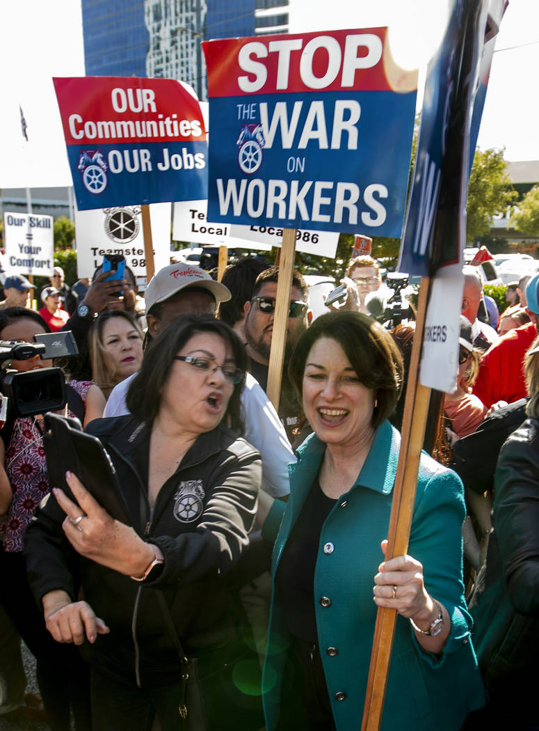 Democratic presidential candidate Sen. Amy Klobuchar, D-Minn., right, marches with workers from ...