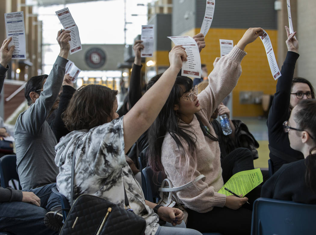 Bernie Sanders supporters hold up their ballots during he first alignment of their group during ...