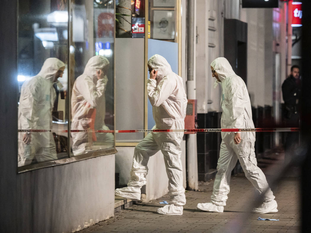 Forensics enter a building at the scene after a shooting in central Hanau, Germany Thursday, Fe ...