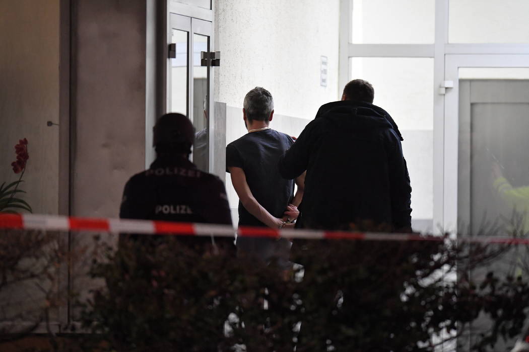 Police handcuff a man near the scene of a shooting in Hanau, Germany early Thursday, Feb. 20, 2 ...