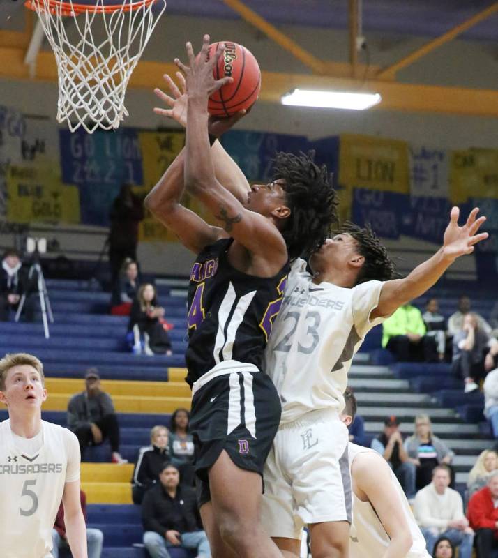 Faith Lutheran's Jackson Williams (23) defends as Durango High's Kendrick Gilbert (24) goes for ...