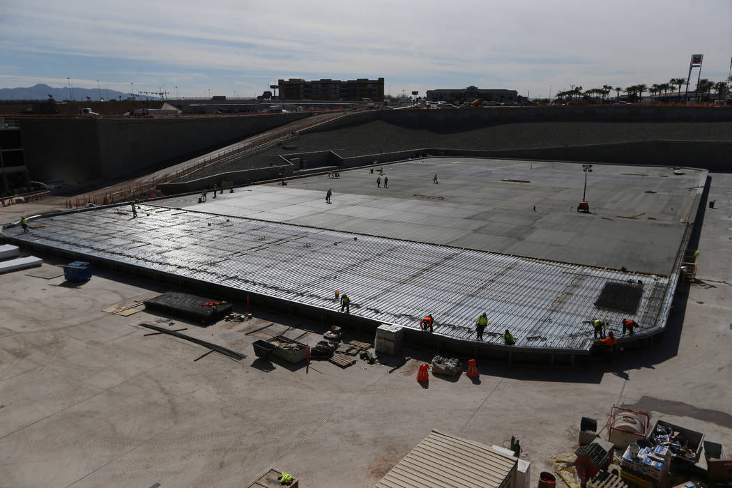 Construction workers prepare a section of the field tray to pour cement at the Raiders Allegian ...