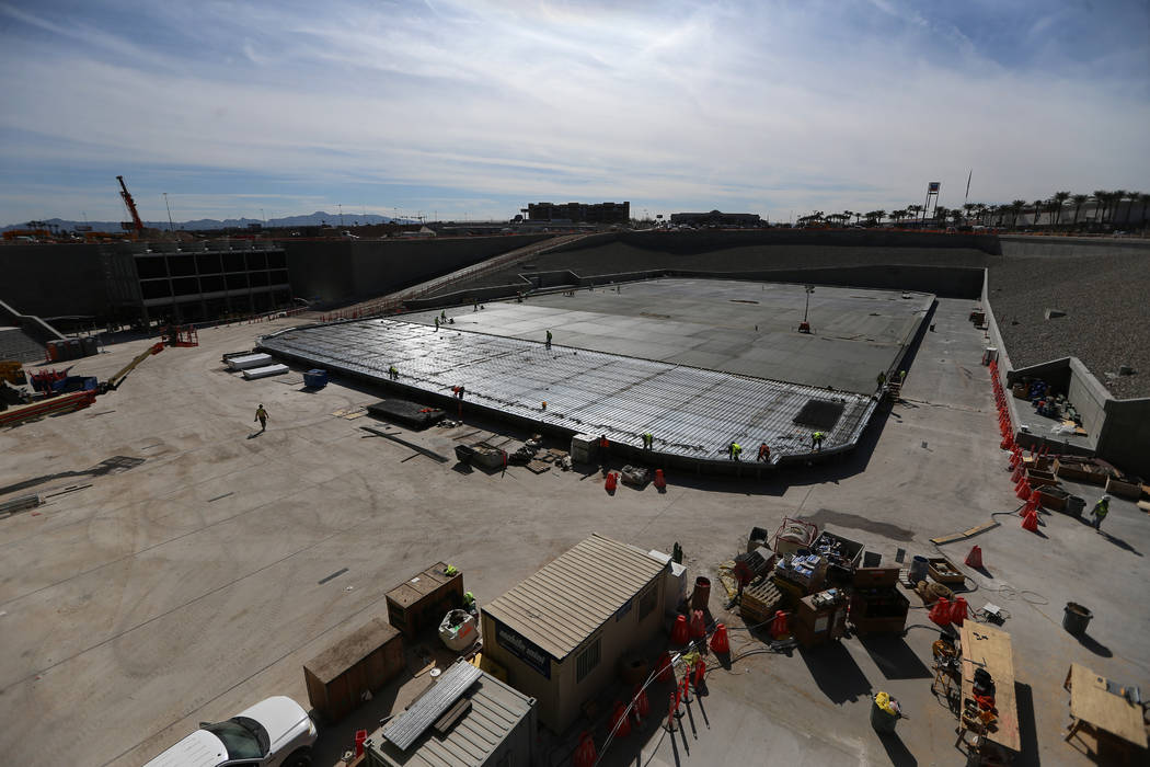 Construction workers prepare a section of the field tray to pour cement at the Raiders Allegian ...