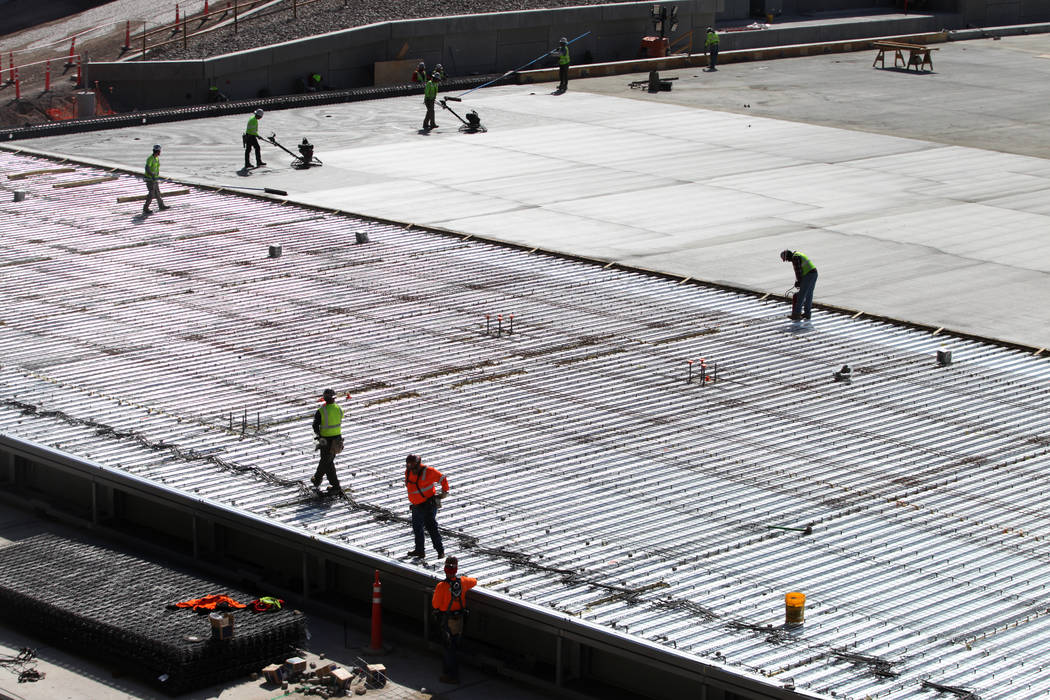 Construction workers prepare a section of the field tray to pour cement at the Raiders Allegian ...