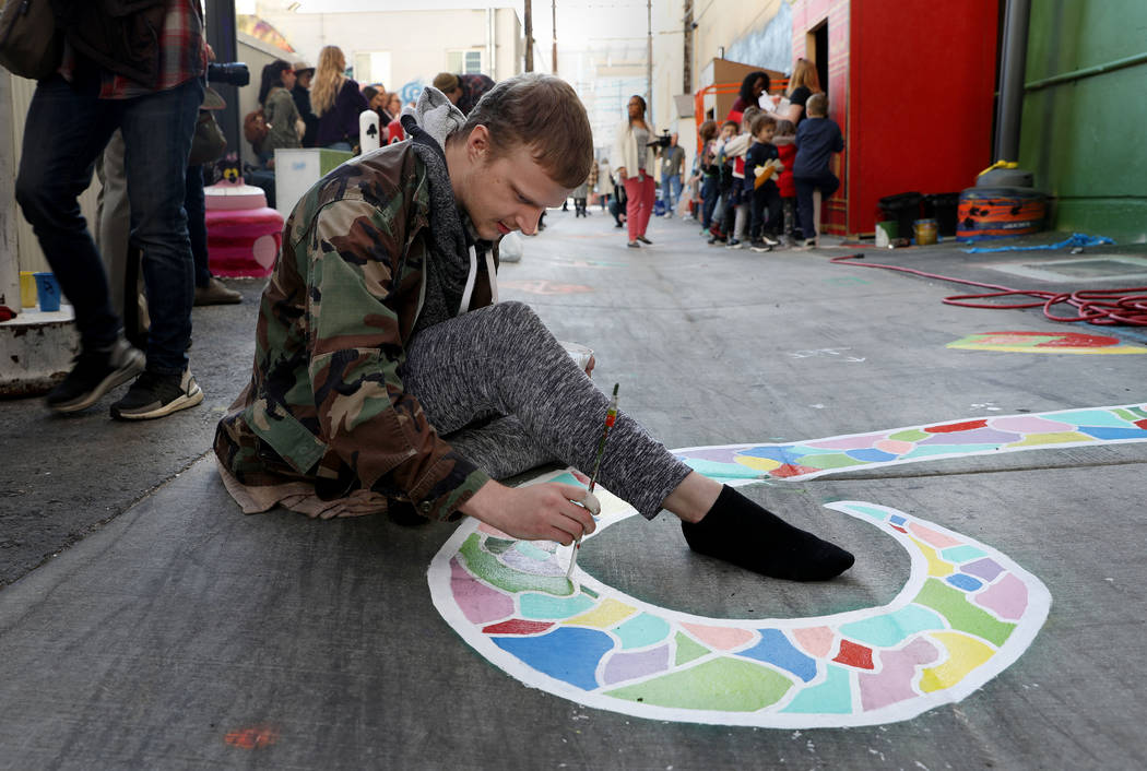 Local muralist Hunter Wilson paints during the grand opening of dT-Alley in Las Vegas on Thursd ...