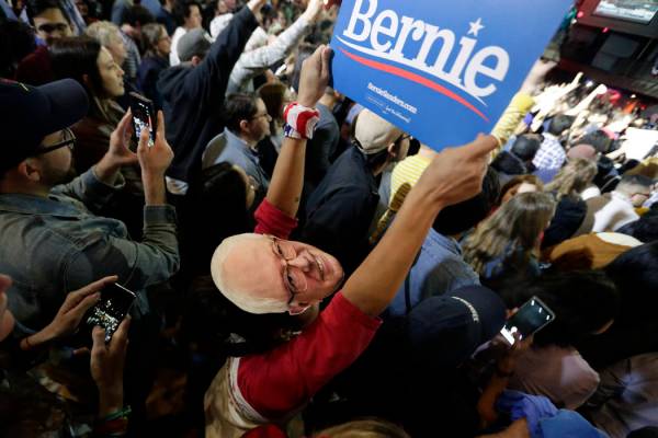 Michelle Nicoleq wears a Bernie Sanders mask as she and other supporters cheer for Democratic p ...