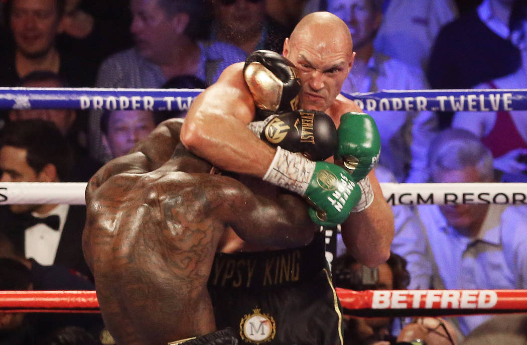 Tyson Fury, top/right, connects with a right hook against Deontay Wilder in the fourth round du ...