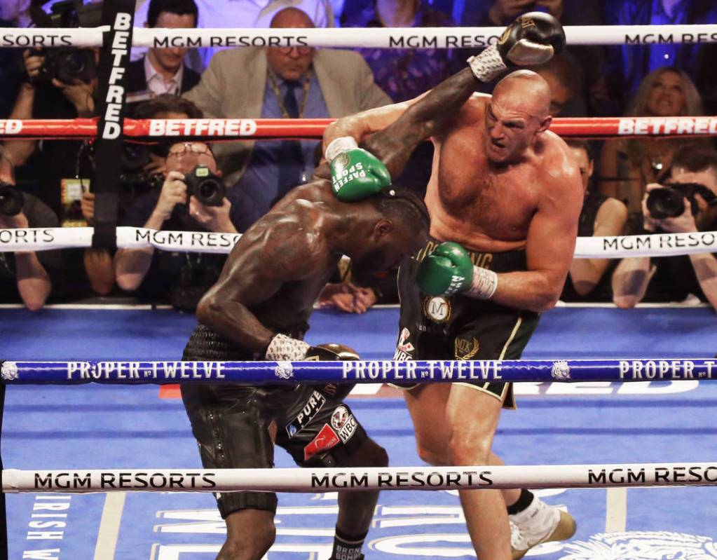 Tyson Fury, right, connects with a right hook against Deontay Wilder in the fifth round during ...