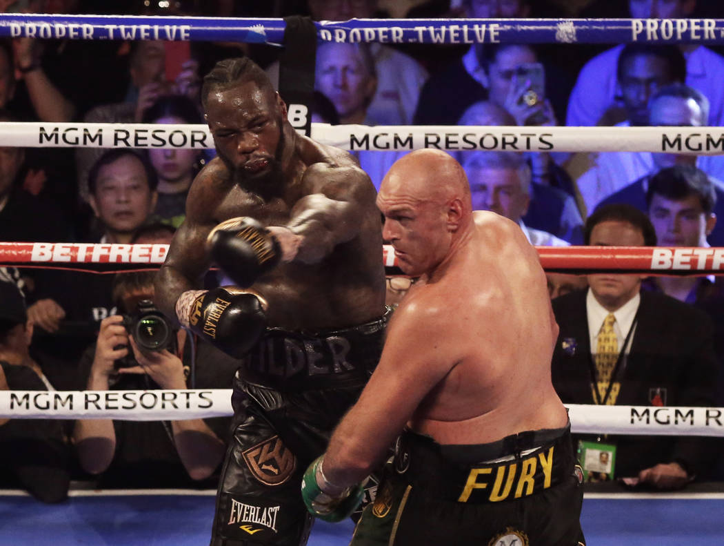 Deontay Wilder, left, connects with a left hook against Tyson Fury in the seventh round during ...