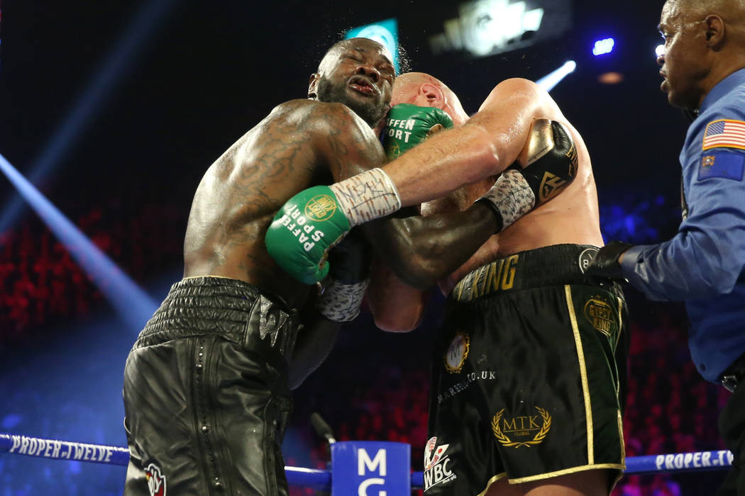 Tyson Fury, right, connects a punch against Deontay Wilder in round 5 of the WBC world heavywei ...