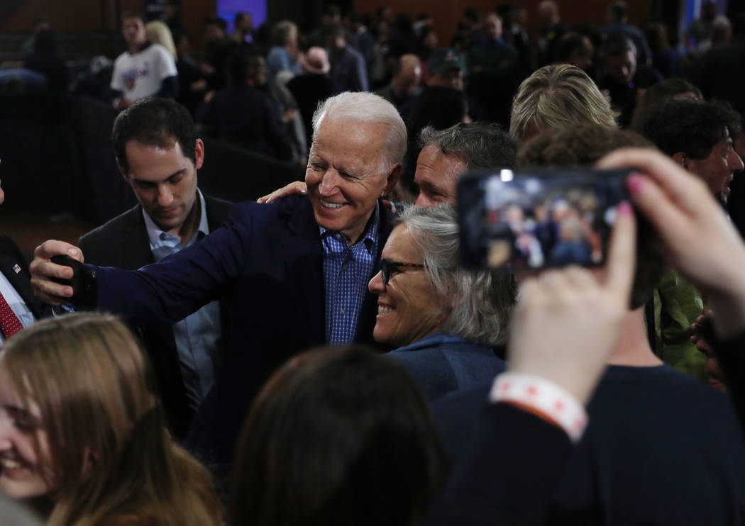 Joe Biden takes photographs with supporters during a caucus night event at IBEW local 357 in La ...