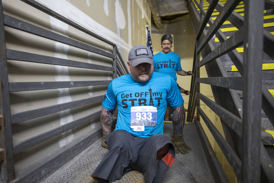 Travis Strong, a double amputee, climbs all of the stairs at the Strat with his arms on Sunday, ...