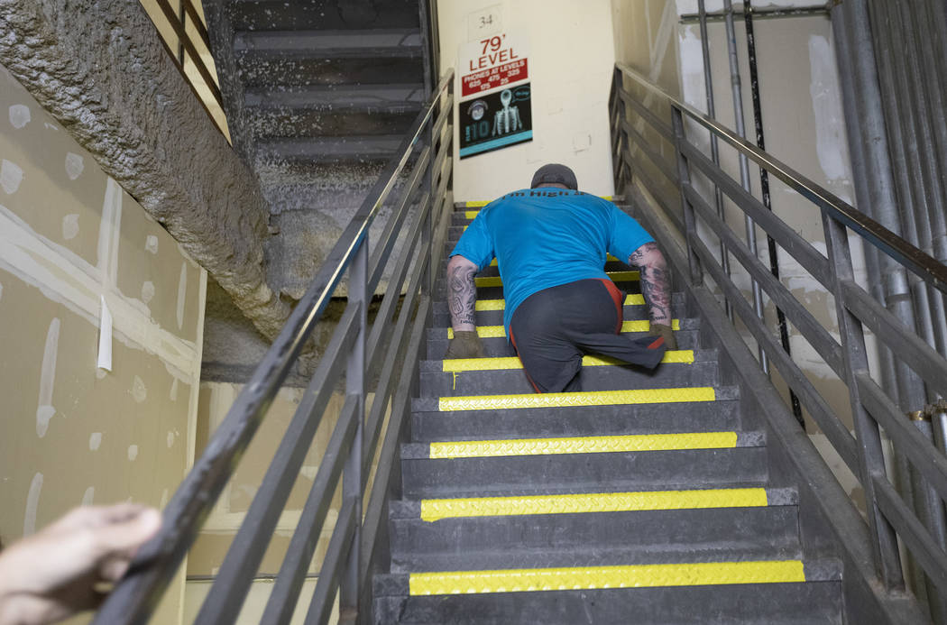 Travis Strong, a double amputee, climbs all of the stairs at the Strat with his arms on Sunday, ...