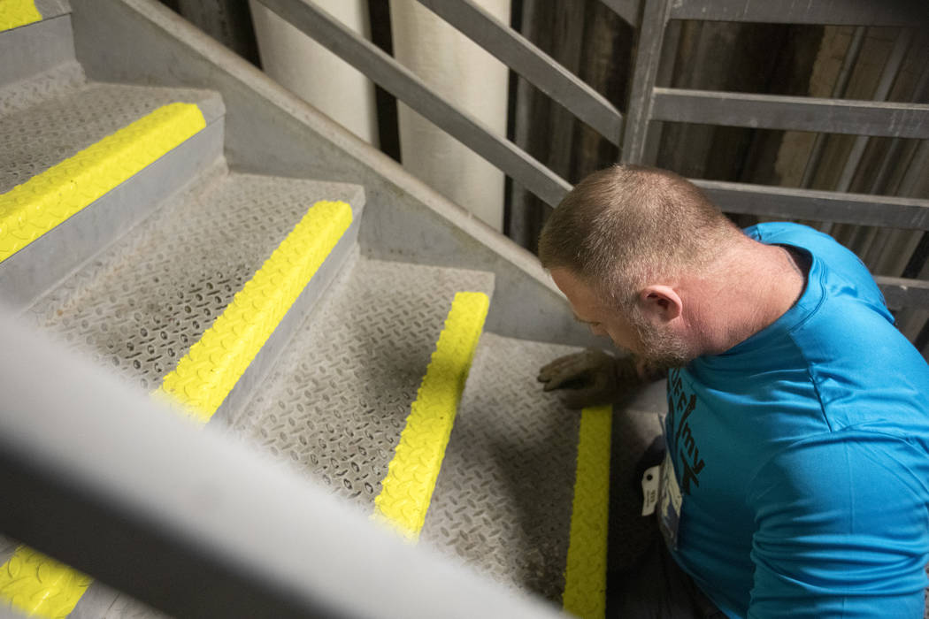 Travis Strong pauses to rest while climbing the 1,455 stairs at the Strat with his arms on Sund ...