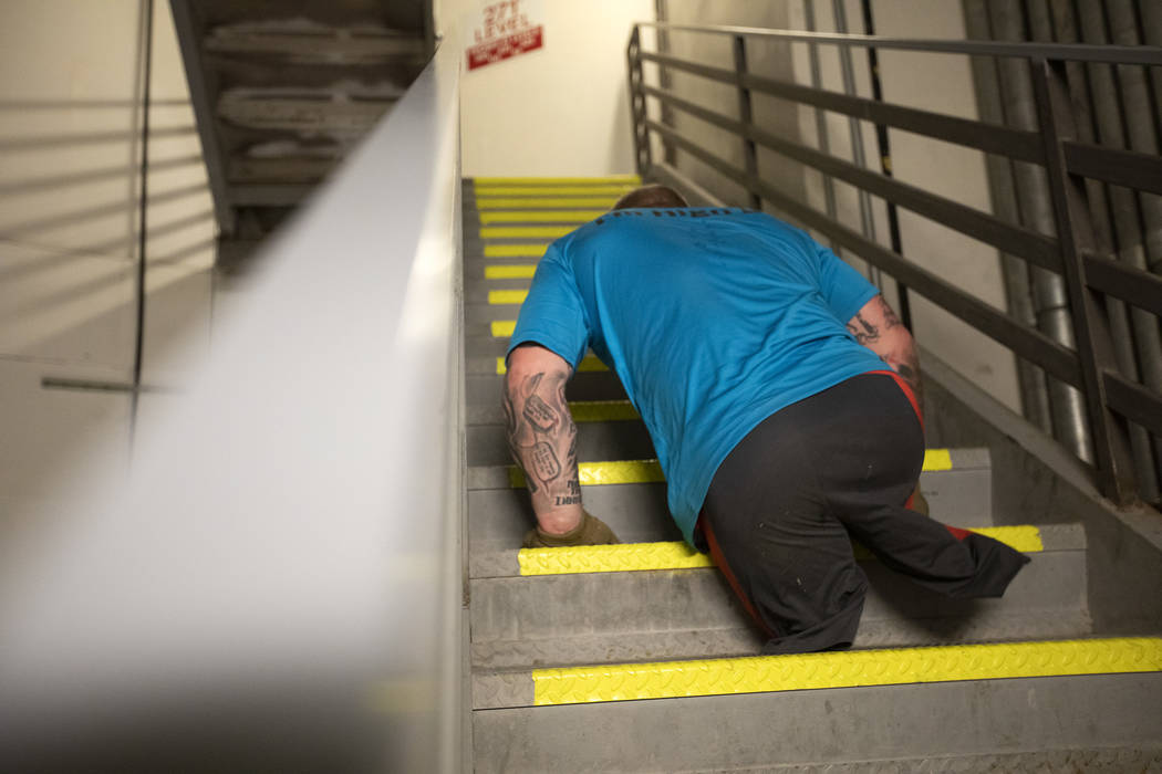 Travis Strong, a double amputee, makes way up the stairs at the Strat with his arms on Sunday, ...