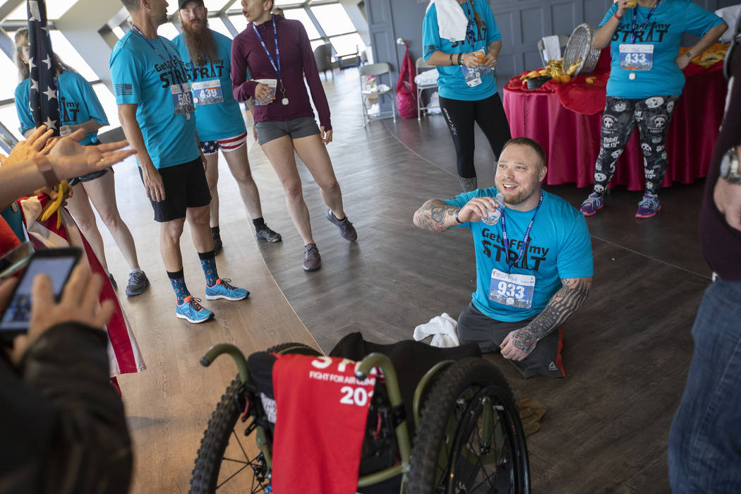 Double amputee and veteran Travis Strong chats with friends and family after climbing all of th ...