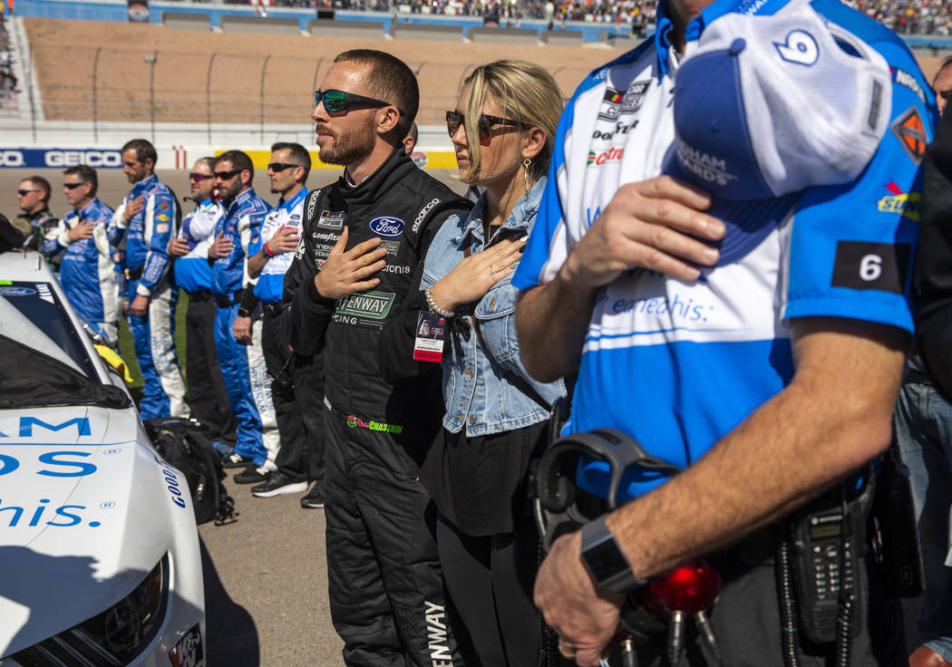 Ross Chastain (6, center) listens to the National Anthem with his crew before the start of the ...