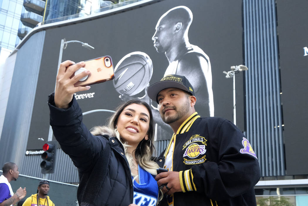 Alyssa Quevedo and her husband Emmanuel take a selfie in front of a mural of Kobe Bryant near t ...