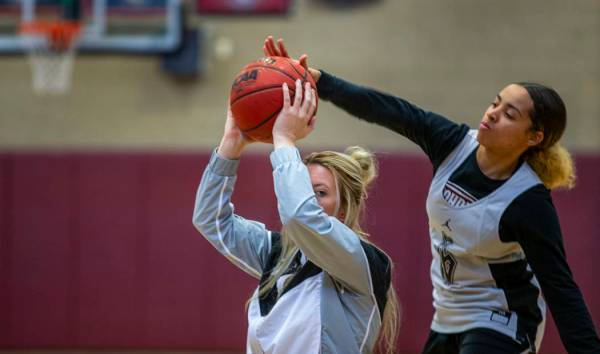 Head coach Laurie Evans, left, holds the ball tight as player Olivia Bigger attempts to swat it ...